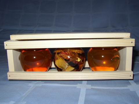 Trije kozarci medu v lesenem zabojku